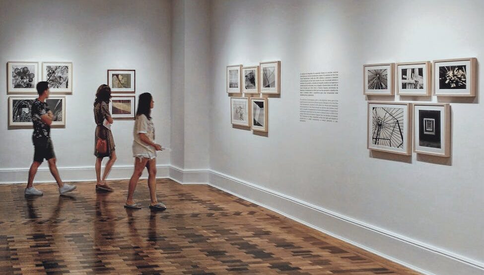 two women and man walking inside building